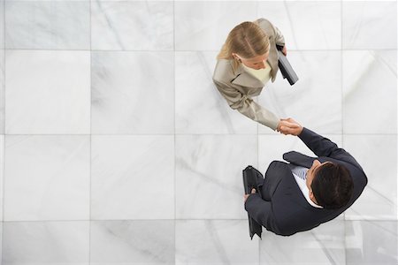 professional hand shake - Two business people shaking hands in lobby Stock Photo - Premium Royalty-Free, Code: 693-03307816