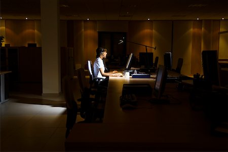 Woman working at laptop in dark office Foto de stock - Sin royalties Premium, Código: 693-03307847