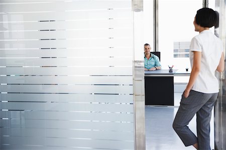 desk with wall - Man talking to woman standing in doorway of his office Stock Photo - Premium Royalty-Free, Code: 693-03307913