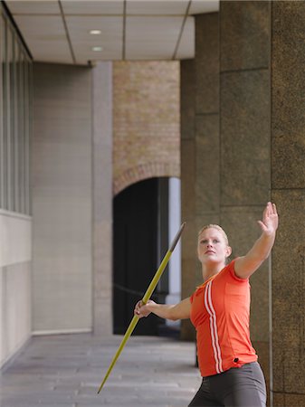 Woman throwing javelin outside building Stock Photo - Premium Royalty-Free, Code: 693-03308155