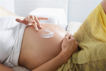 Schwangere Frau schmieren Lotion auf Magen im Schlafzimmer, Mitte Abschnitt Stockbilder - Premium RF Lizenzfrei, Bildnummer: 693-03308176