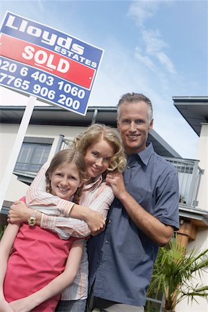 family with sold sign - Parents and daughter (7-9) embracing outside new home, portrait Stock Photo - Premium Royalty-Free, Code: 693-03308235