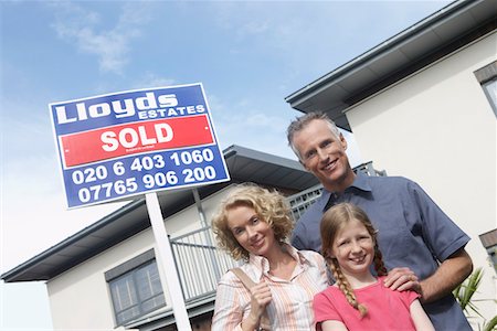 pictures of families with the sold sign on new house - Parents and daughter (7-9) embracing outside new home, portrait Stock Photo - Premium Royalty-Free, Code: 693-03308236