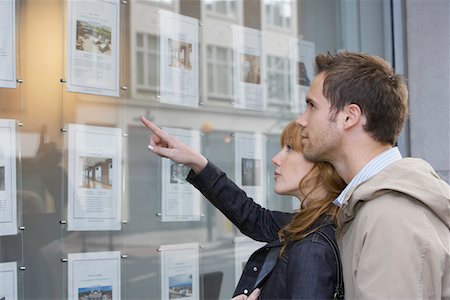 real estate agents and couples - Couple looking in window outside estate agents Stock Photo - Premium Royalty-Free, Code: 693-03308312