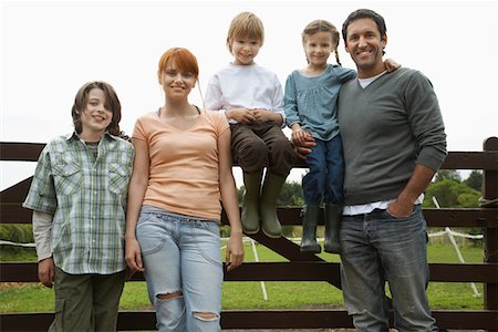 Parents with three children (5-9) by fence in countryside, portrait Stock Photo - Premium Royalty-Free, Code: 693-03308412