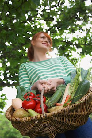 fruits basket low angle - Woman holding fruit and vegetable basket, outdoors Foto de stock - Sin royalties Premium, Código: 693-03308466