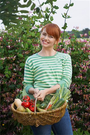 striped tomato - Woman holding fruit and vegetable basket in garden, portrait Stock Photo - Premium Royalty-Free, Code: 693-03308462