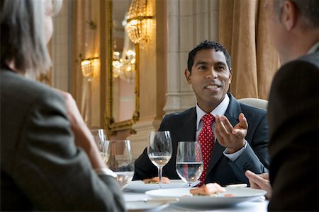 Three business people sitting at restaurant table, talking Stock Photo - Premium Royalty-Free, Code: 693-03308639