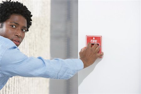 despair african american - Man starting fire alarm, indoors Stock Photo - Premium Royalty-Free, Code: 693-03308773