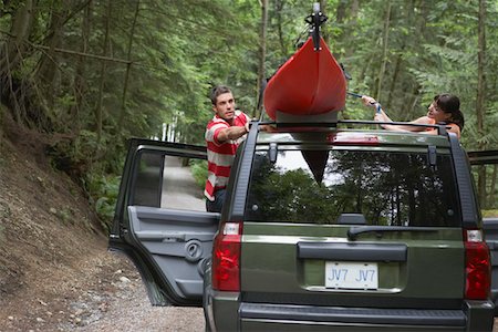 Man tying kayak on car roof, in forest Stock Photo - Premium Royalty-Free, Code: 693-03309079