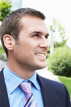 simsearch:693-03565397,k - Businessman looking away, smiling outdoors, close-up Stock Photo - Premium Royalty-Free, Code: 693-03309117