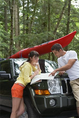 simsearch:693-03309039,k - Couple observing map on car bonnet in forest Fotografie stock - Premium Royalty-Free, Codice: 693-03309110