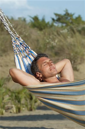 pictures of men sleeping in hammocks - Mid adult man relaxing in hammock Stock Photo - Premium Royalty-Free, Code: 693-03309161