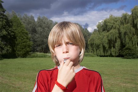 fischietto - Portrait of boy (7-9) blowing whistle in meadow Fotografie stock - Premium Royalty-Free, Codice: 693-03309209