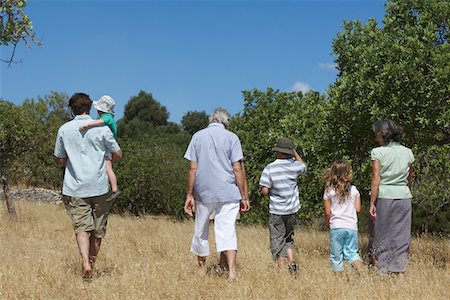 simsearch:693-03304775,k - Three-generation family with three children (3-11) walking in field, back view Stock Photo - Premium Royalty-Free, Code: 693-03309245