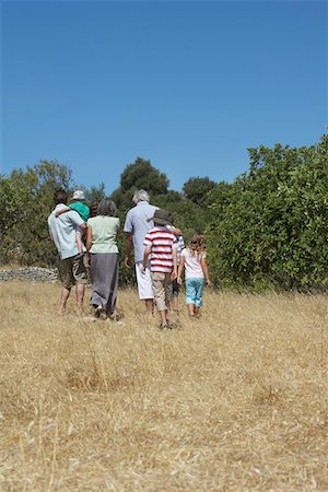 simsearch:693-03304775,k - Three-generation family with three children (3-11) walking in field, back view Stock Photo - Premium Royalty-Free, Code: 693-03309247