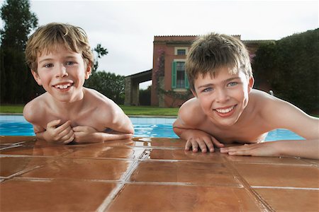 swimming pool leaning on edge - Portrait of two boys (6-11) leaning on edge of pool Stock Photo - Premium Royalty-Free, Code: 693-03309371