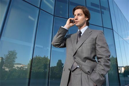 simsearch:693-03307925,k - Business man using mobile phone outside office building Fotografie stock - Premium Royalty-Free, Codice: 693-03309897