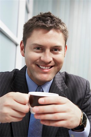 simsearch:693-03311509,k - Businessman Holding Coffee Cup, portrait, head and shoulders Stock Photo - Premium Royalty-Free, Code: 693-03300052