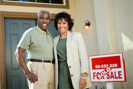 Middle-aged couple standing in front of new home, portrait Stock Photo - Premium Royalty-Free, Code: 693-03300060