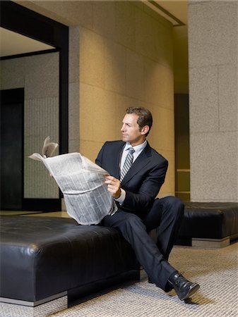 Businessman reading newspaper in lobby Stock Photo - Premium Royalty-Free, Code: 693-03300205