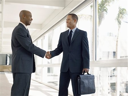 Businessmen shaking hands in hallway Stock Photo - Premium Royalty-Free, Code: 693-03300219