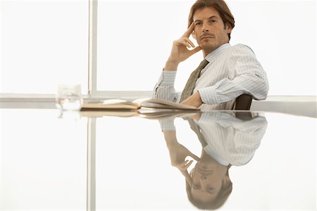 simsearch:693-03564532,k - Serious businessman sitting at conference table Stock Photo - Premium Royalty-Free, Code: 693-03300285