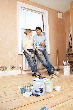 simsearch:693-03308062,k - Couple taking a break from painting living room Fotografie stock - Premium Royalty-Free, Codice: 693-03300538