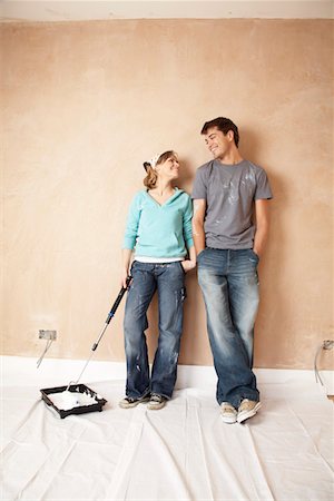 Couple standing with paint roller in unrenovated room Stock Photo - Premium Royalty-Free, Code: 693-03300530