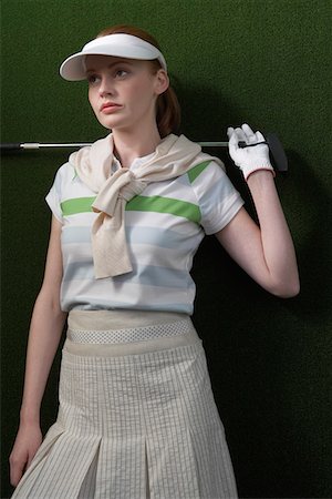 Woman in visor holding golf club behind shoulders, portrait Stock Photo - Premium Royalty-Free, Code: 693-03300677