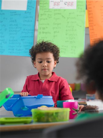 Garçon à la recherche dans la boîte à lunch en salle de classe Photographie de stock - Premium Libres de Droits, Code: 693-03300735