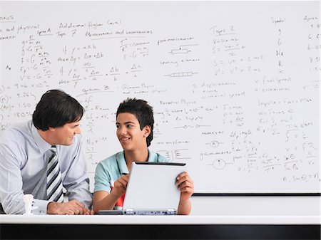 Teacher and student using laptop sitting in physics classroom Stock Photo - Premium Royalty-Free, Code: 693-03300773