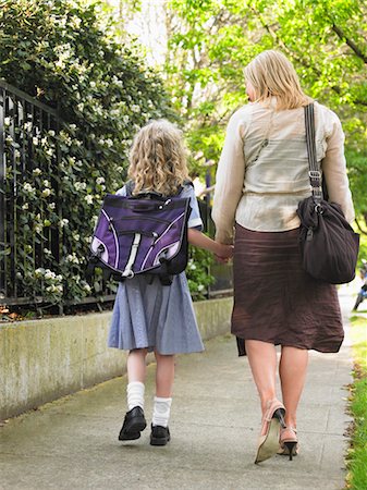 Elementary schoolgirl walking with mother on pavement, back view Stock Photo - Premium Royalty-Free, Code: 693-03300831