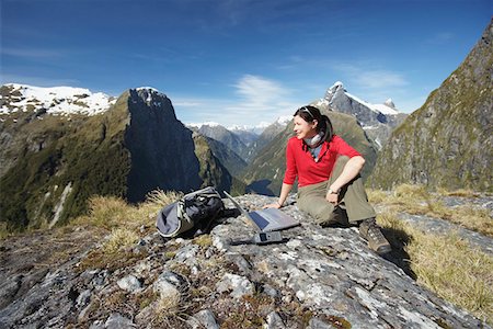 fiordland national park - Woman sitting with laptop on mountain peak Foto de stock - Sin royalties Premium, Código: 693-03300894