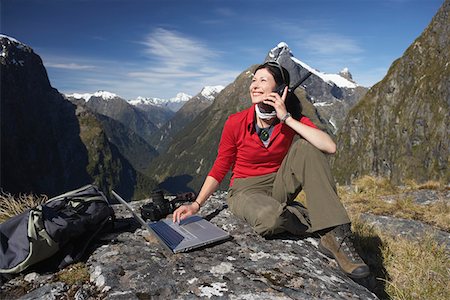 fiordland national park - Woman using walkie-talkie and laptop on mountain peak Foto de stock - Sin royalties Premium, Código: 693-03300895