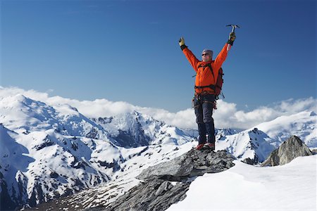 Mountain climber with arms raised on top of mountain peak Stock Photo - Premium Royalty-Free, Code: 693-03300982