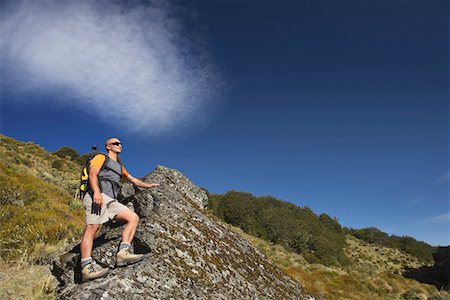 Man climbing up boulder in forest valley Fotografie stock - Premium Royalty-Free, Codice: 693-03301019