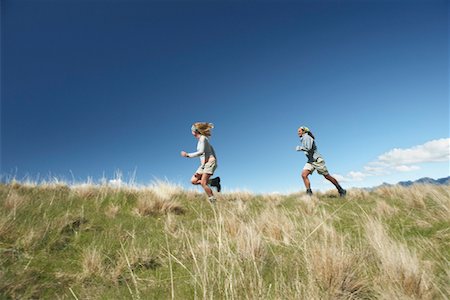 Man and woman running through field Fotografie stock - Premium Royalty-Free, Codice: 693-03301056