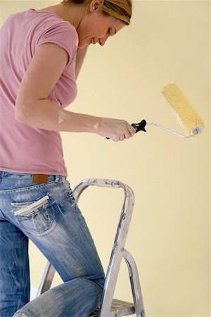 Woman on ladder with paint roller Stock Photo - Premium Royalty-Free, Code: 693-03301098