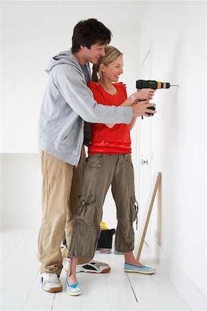 drilling wall - Couple drilling inside their new home Stock Photo - Premium Royalty-Free, Code: 693-03301091