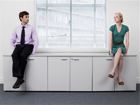 Businesspeople sitting on office cabinets Stock Photo - Premium Royalty-Free, Code: 693-03301299