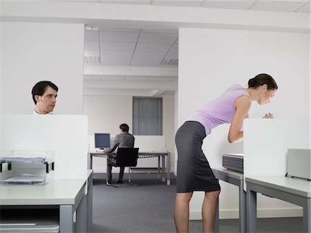 Businessman watching female colleague in office Foto de stock - Sin royalties Premium, Código: 693-03301326