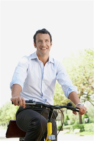 daily routine - Businessman commuting by bike along tree lined road Stock Photo - Premium Royalty-Free, Code: 693-03301439