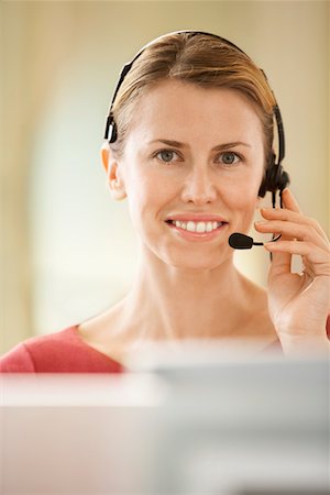 Mid-adult female office worker sitting in cubicle wearing headset, portrait Stock Photo - Premium Royalty-Free, Code: 693-03301737