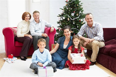 Family sitting by christmas tree in living room, portrait Foto de stock - Sin royalties Premium, Código: 693-03301821