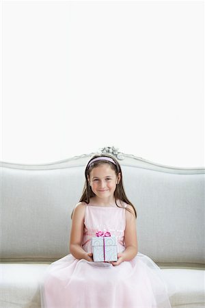 preteen nylon - Smiling girl in tutu sitting on sofa holding gift, portrait Stock Photo - Premium Royalty-Free, Code: 693-03301835
