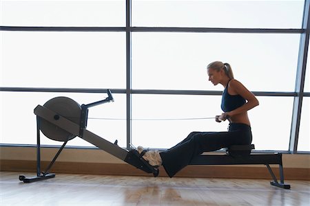 rowing machine - Women Using Rowing Machine in health club, side view Stock Photo - Premium Royalty-Free, Code: 693-03301851