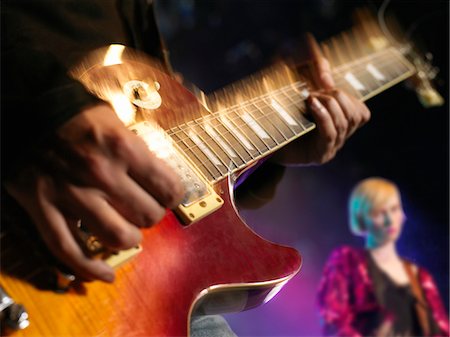 Rock Guitarist on stage in Concert, mid-section, close up of guitar Stock Photo - Premium Royalty-Free, Code: 693-03302020