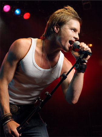 simsearch:693-03302042,k - Young Man Singing into microphone on stage at Concert, low angle view Stock Photo - Premium Royalty-Free, Code: 693-03302038