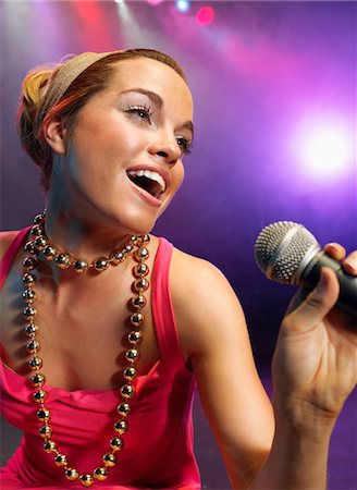 simsearch:693-03302100,k - Jeune femme chantant sur scène en Concert, gros plan, faible angle vue Photographie de stock - Premium Libres de Droits, Code: 693-03302032